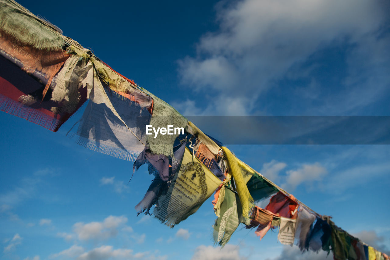 Low angle view of prayer flags hanging against sky