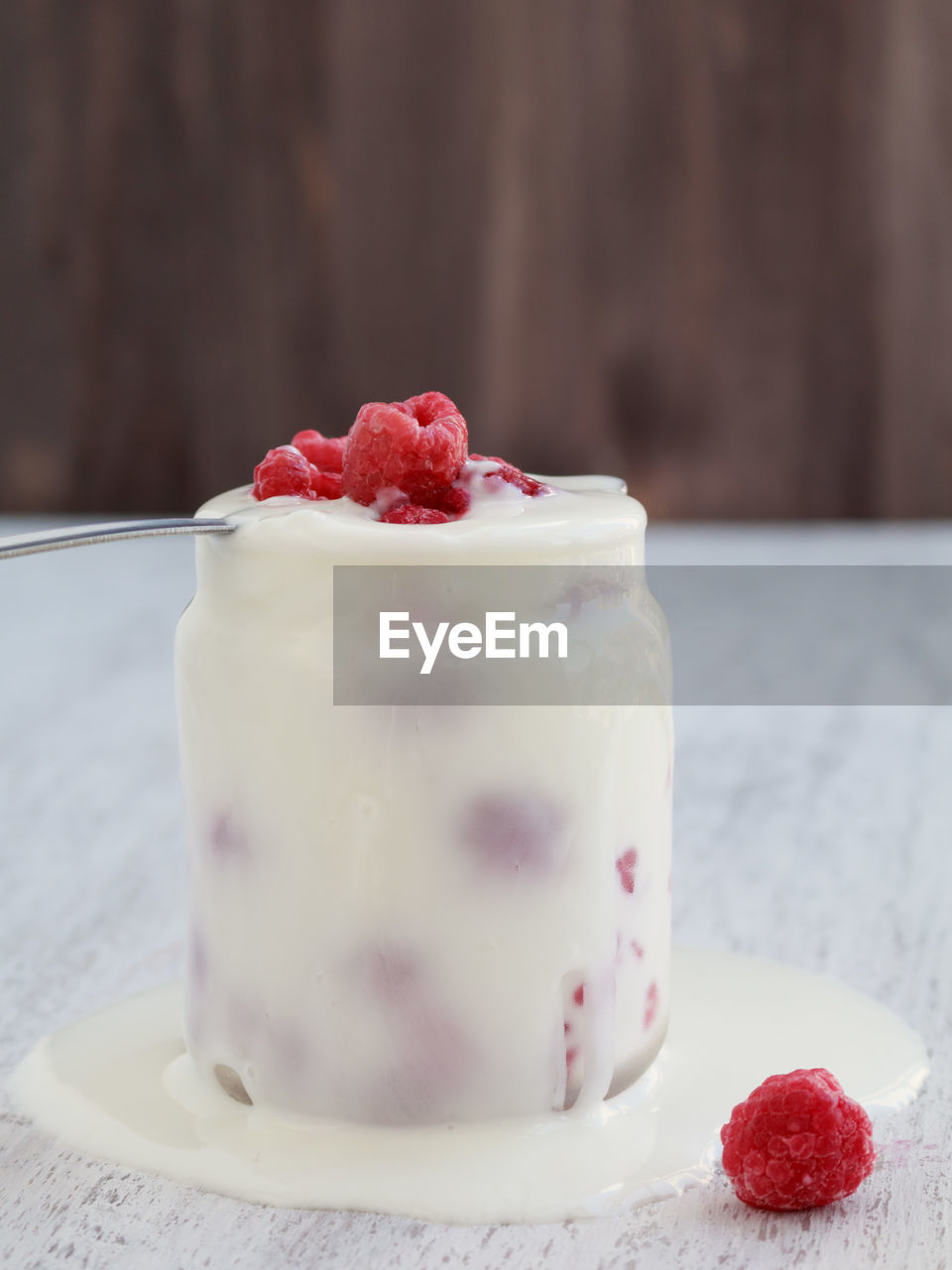Close-up of raspberries with whipped cream in jar on table