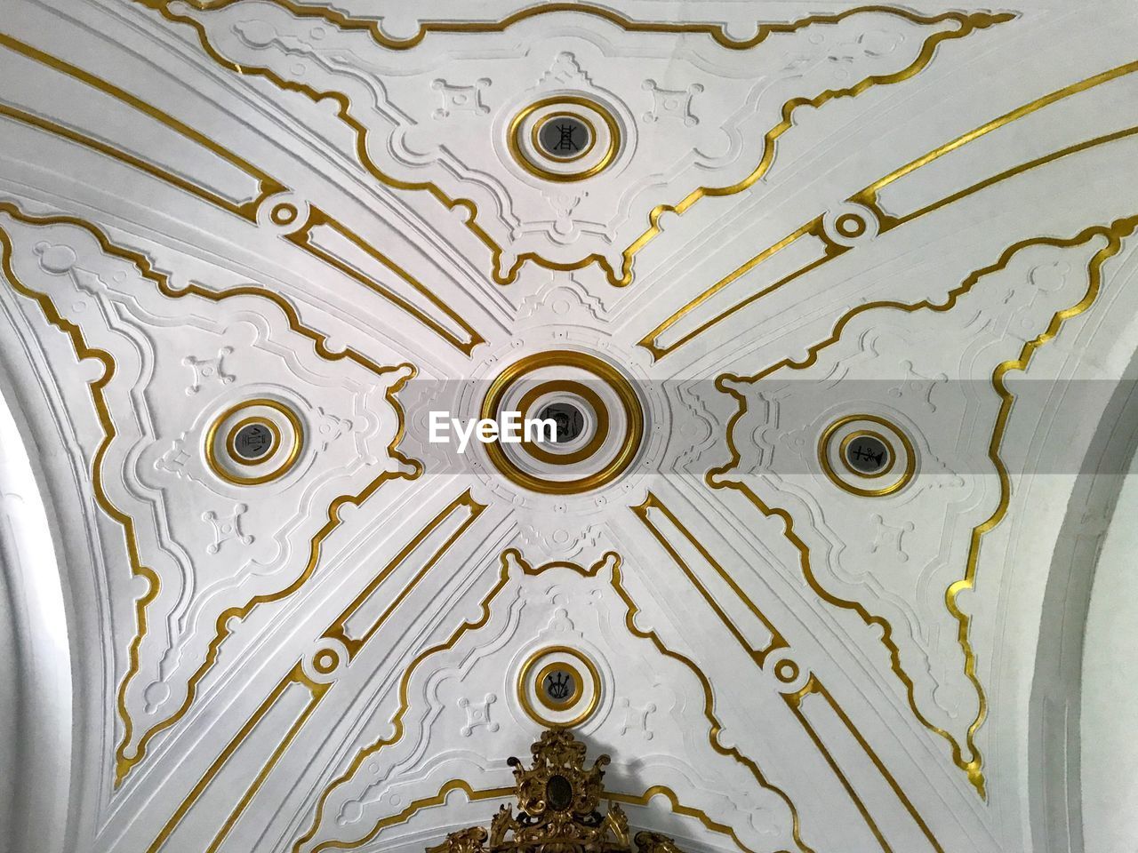 DIRECTLY BELOW SHOT OF ORNATE CEILING AGAINST BUILDING