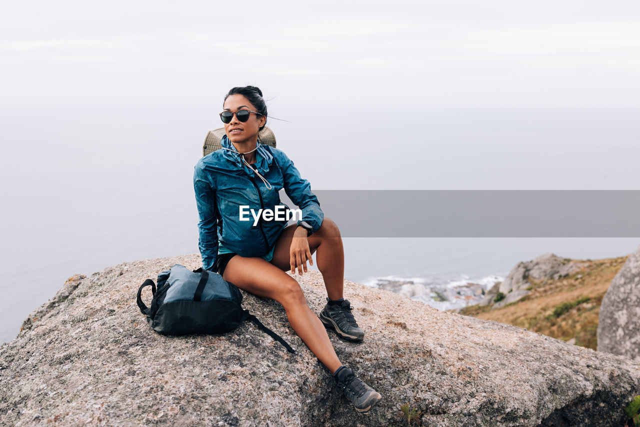 Full length of woman sitting on rock