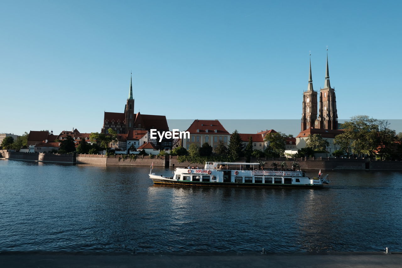 BOATS IN RIVER WITH CATHEDRAL IN BACKGROUND