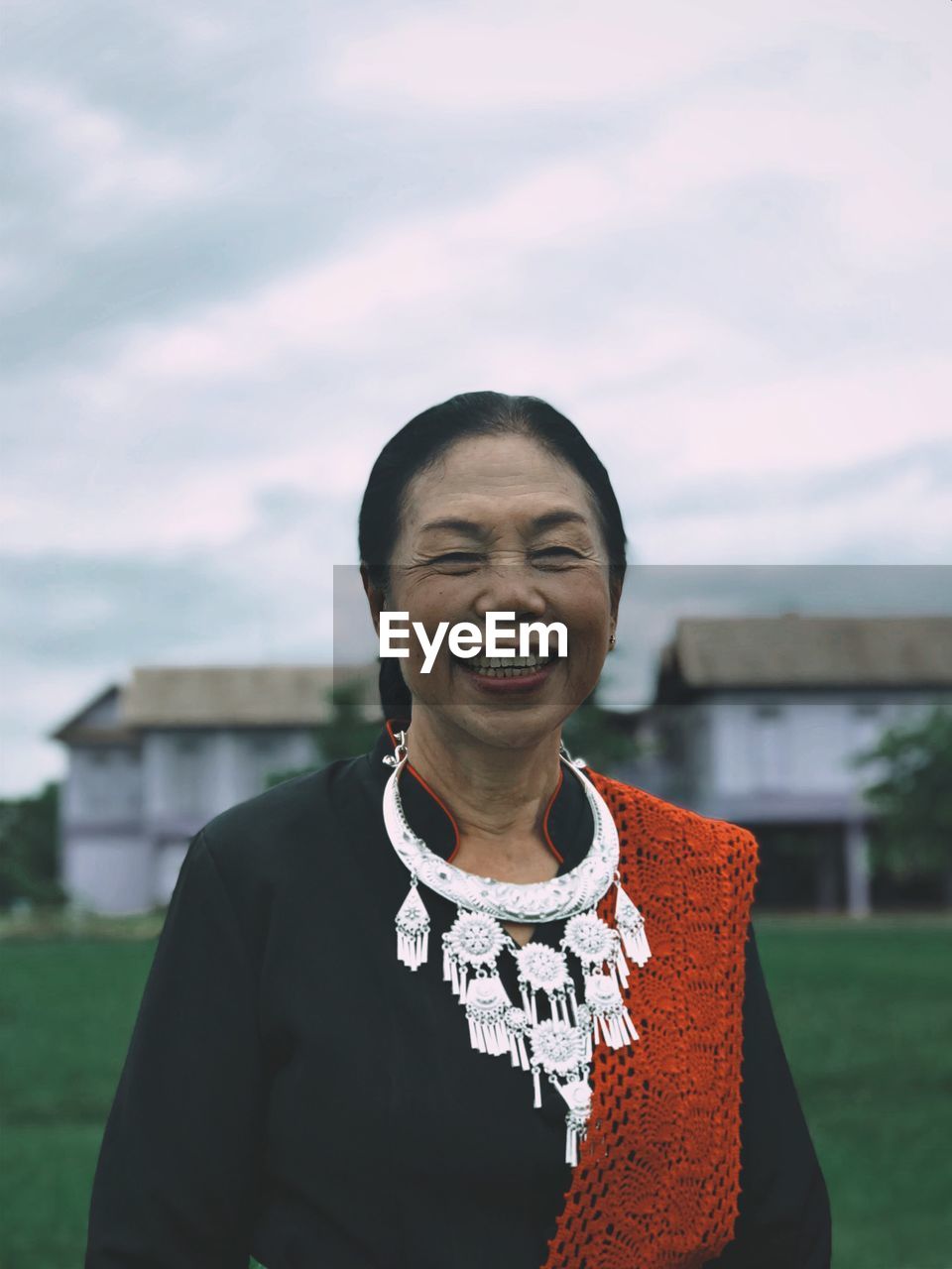 Portrait of smiling mature woman standing on field