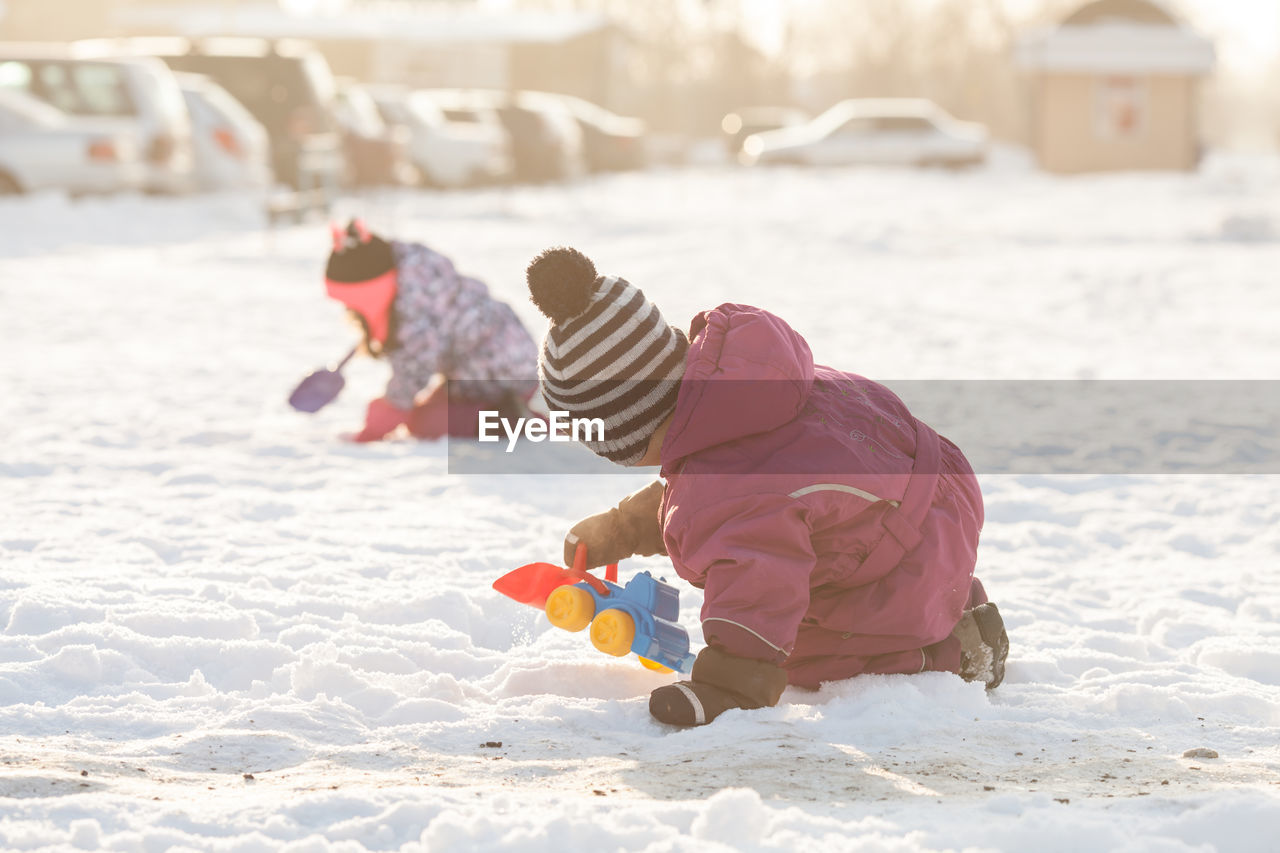 GIRL PLAYING WITH SNOW