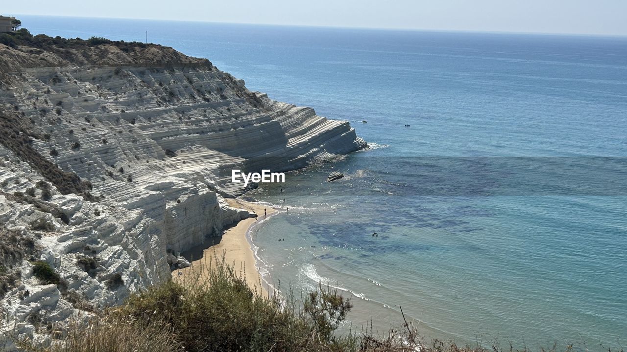 sea, water, cliff, scenics - nature, land, beauty in nature, beach, coast, horizon over water, terrain, nature, horizon, sky, tranquility, tranquil scene, rock, ocean, shore, rock formation, no people, day, non-urban scene, coastline, high angle view, idyllic, outdoors, travel destinations, blue, bay, travel, environment, body of water, wave, clear sky