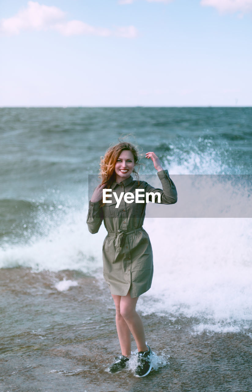 WOMAN STANDING AT BEACH