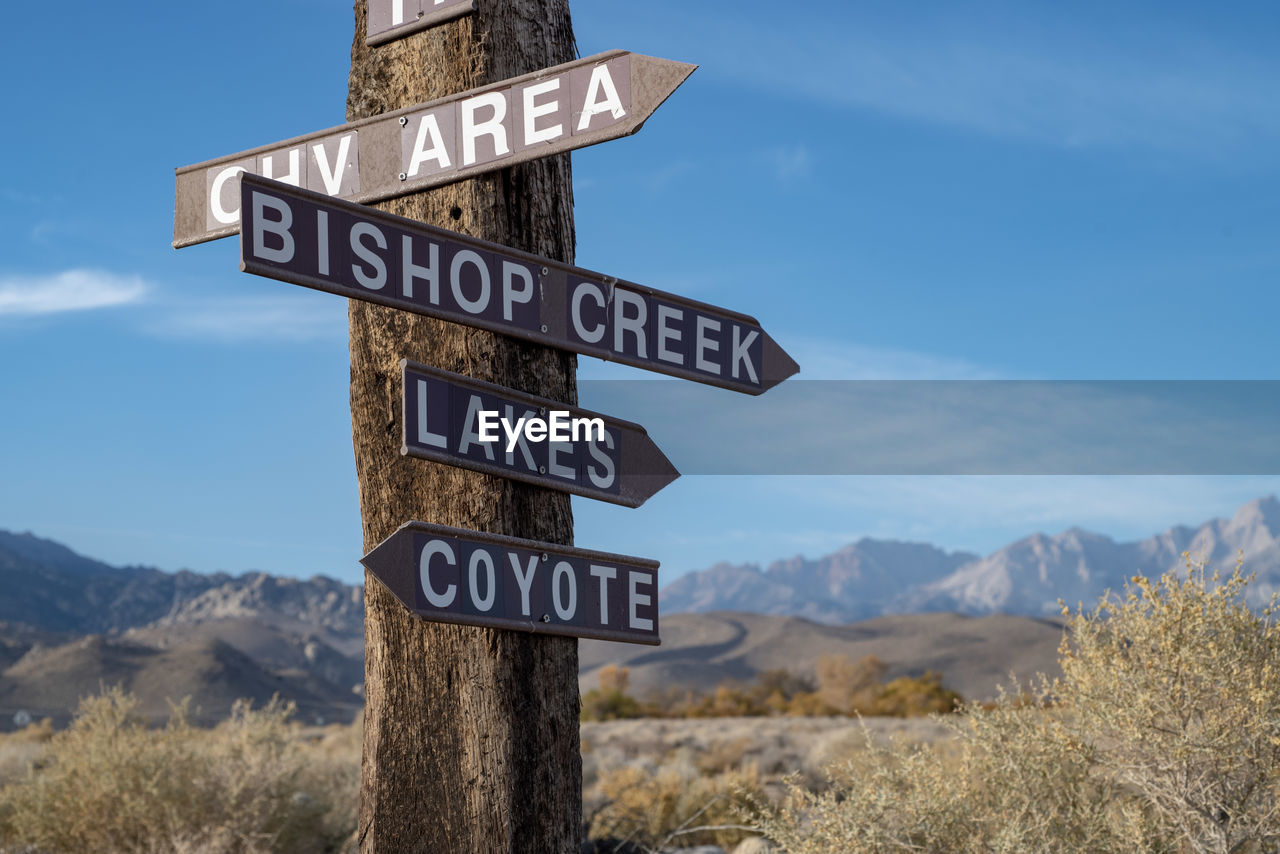 Wood sign post and directional arrows in rural america desert mountains 