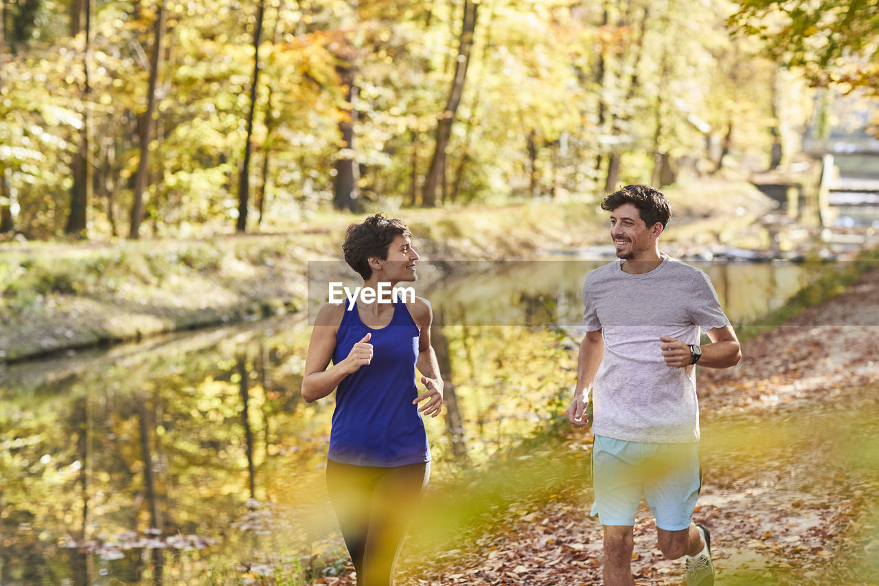 Couple jogging on autumnally forest track