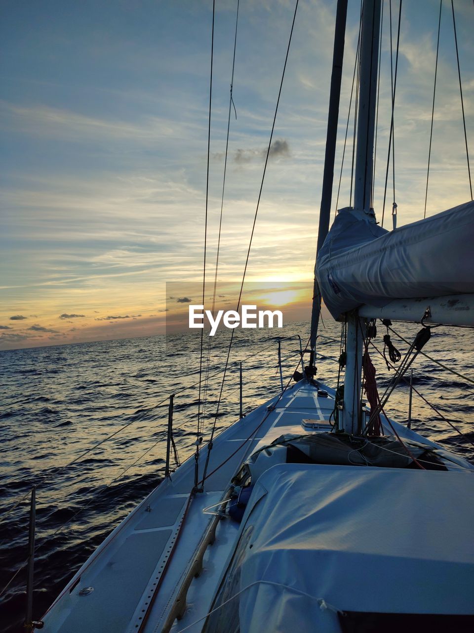 sea, water, transportation, nautical vessel, sailboat, mode of transportation, sky, sailing, sunset, boat, nature, cloud, vehicle, sailing ship, travel, beauty in nature, mast, yacht, ship, watercraft, rope, pole, holiday, luxury, vacation, horizon over water, no people, horizon, scenics - nature, rigging, trip, outdoors, boat deck, environment, deck, tranquility, blue, cruise, motion, tranquil scene, sunlight, travel destinations, yachting, idyllic, sun, windsports