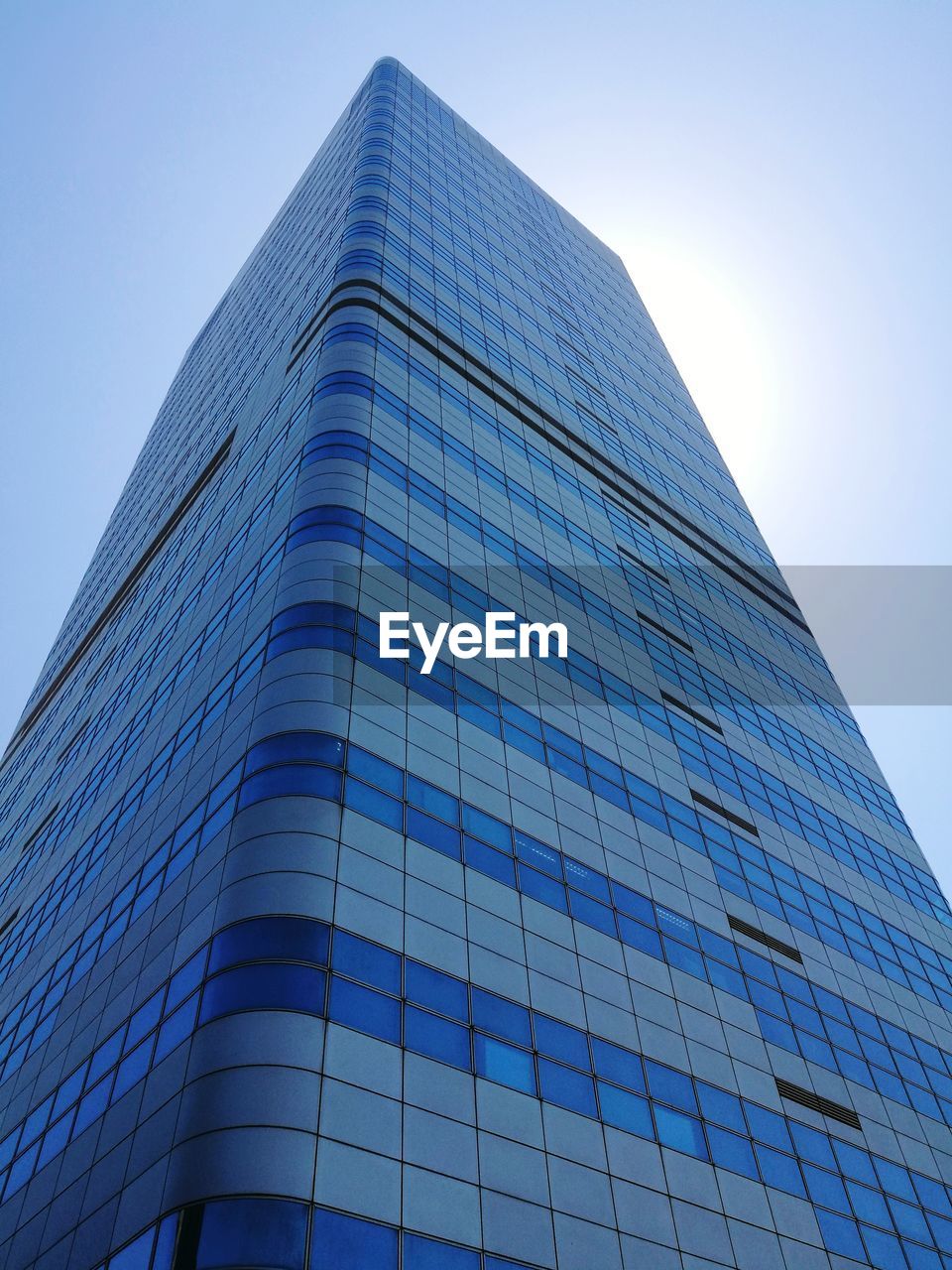 Low angle view of office building against blue sky