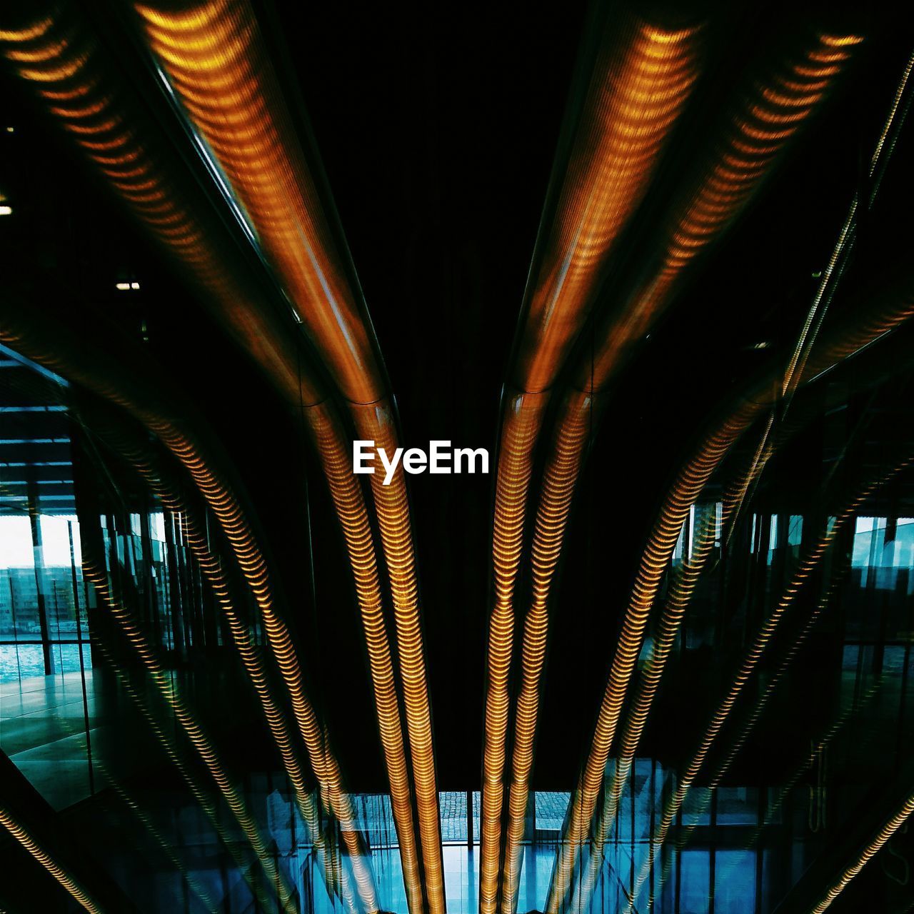 Illuminated orange neon lights with reflection glass in building