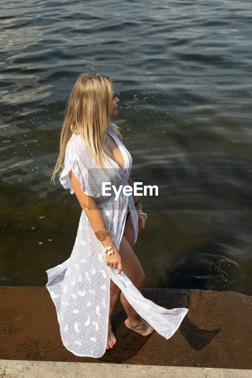 WOMAN STANDING AT LAKE