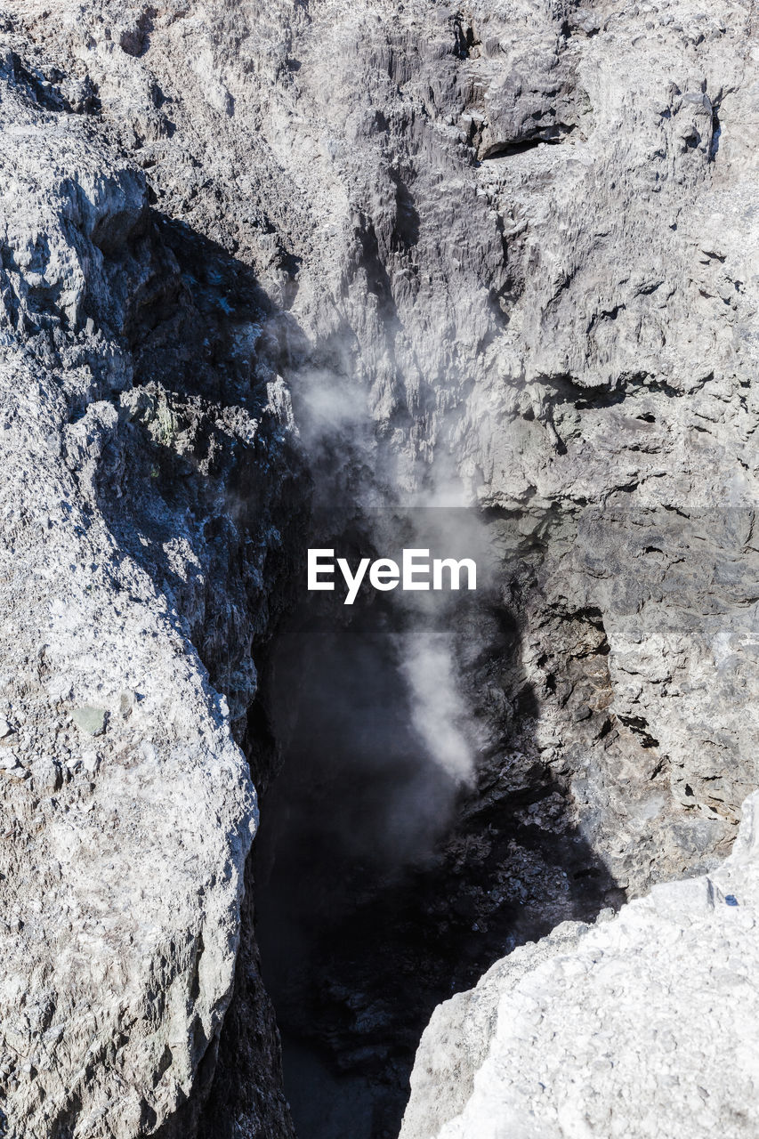 HIGH ANGLE VIEW OF ROCK FORMATIONS IN SEA