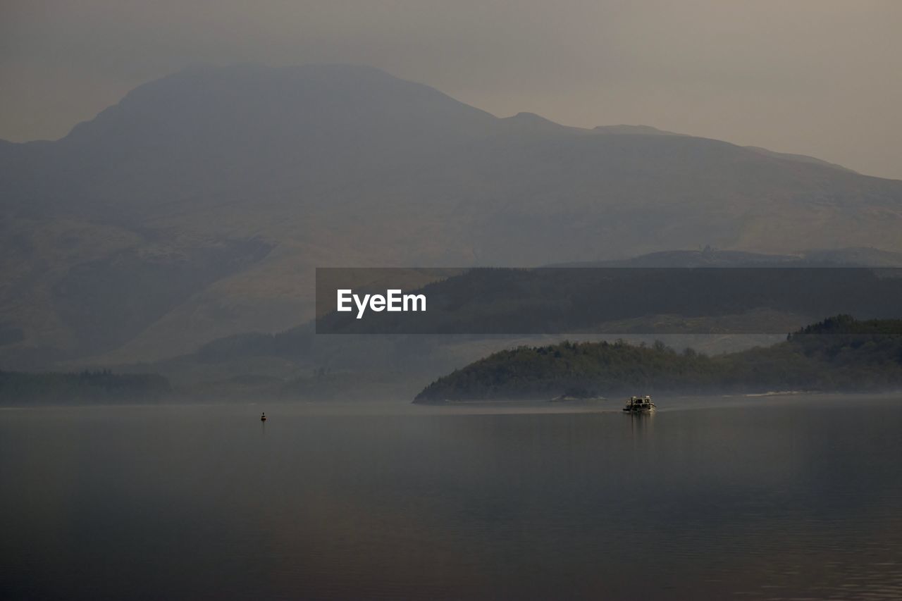 Scenic view of sea and mountains against sky