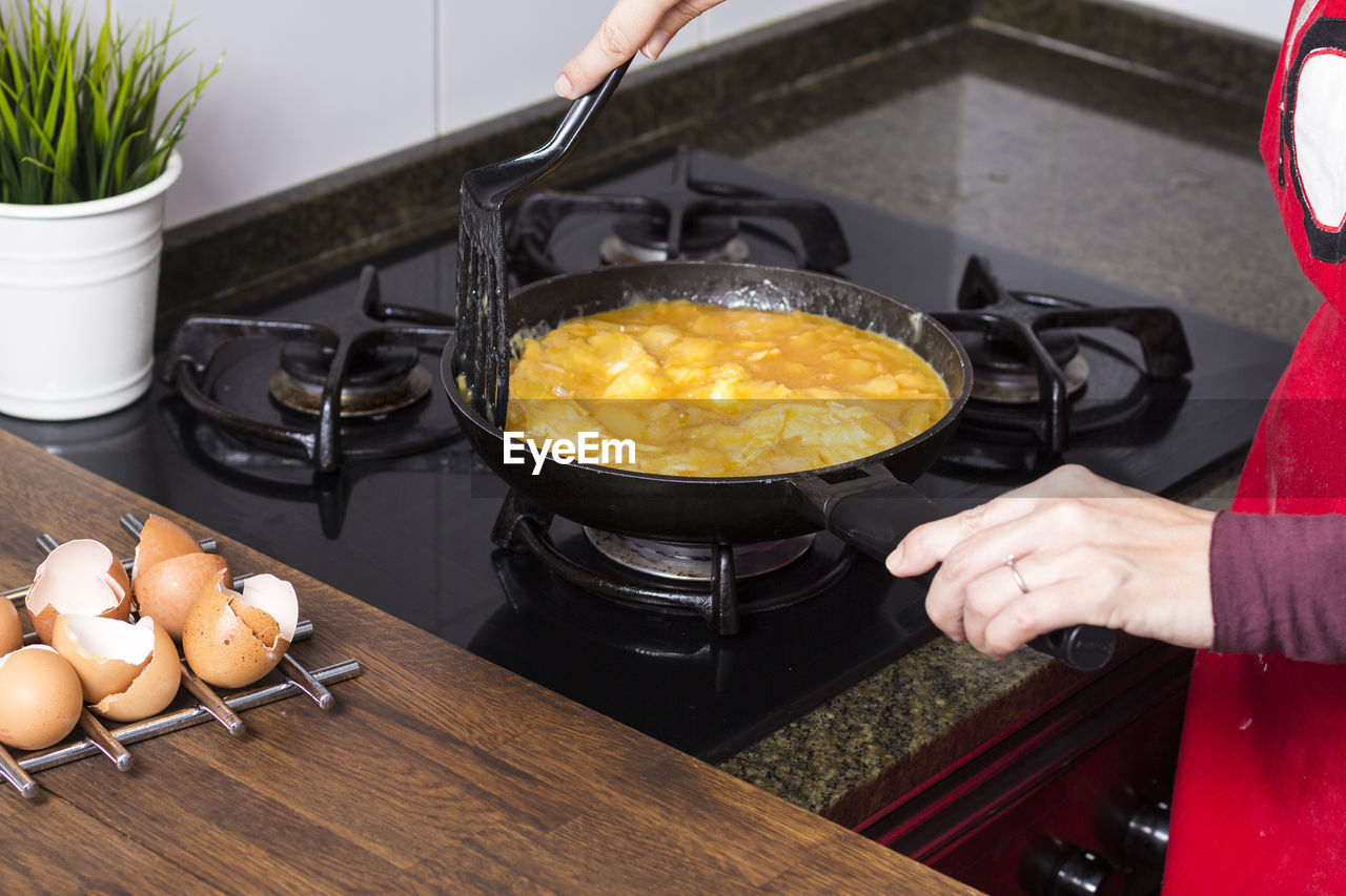 Midsection of woman preparing food in kitchen