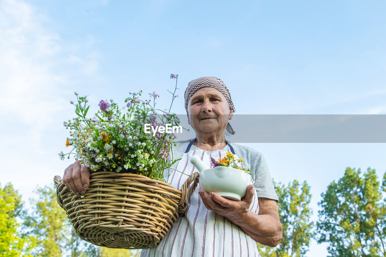 low angle view of smiling young woman standing against clear sky