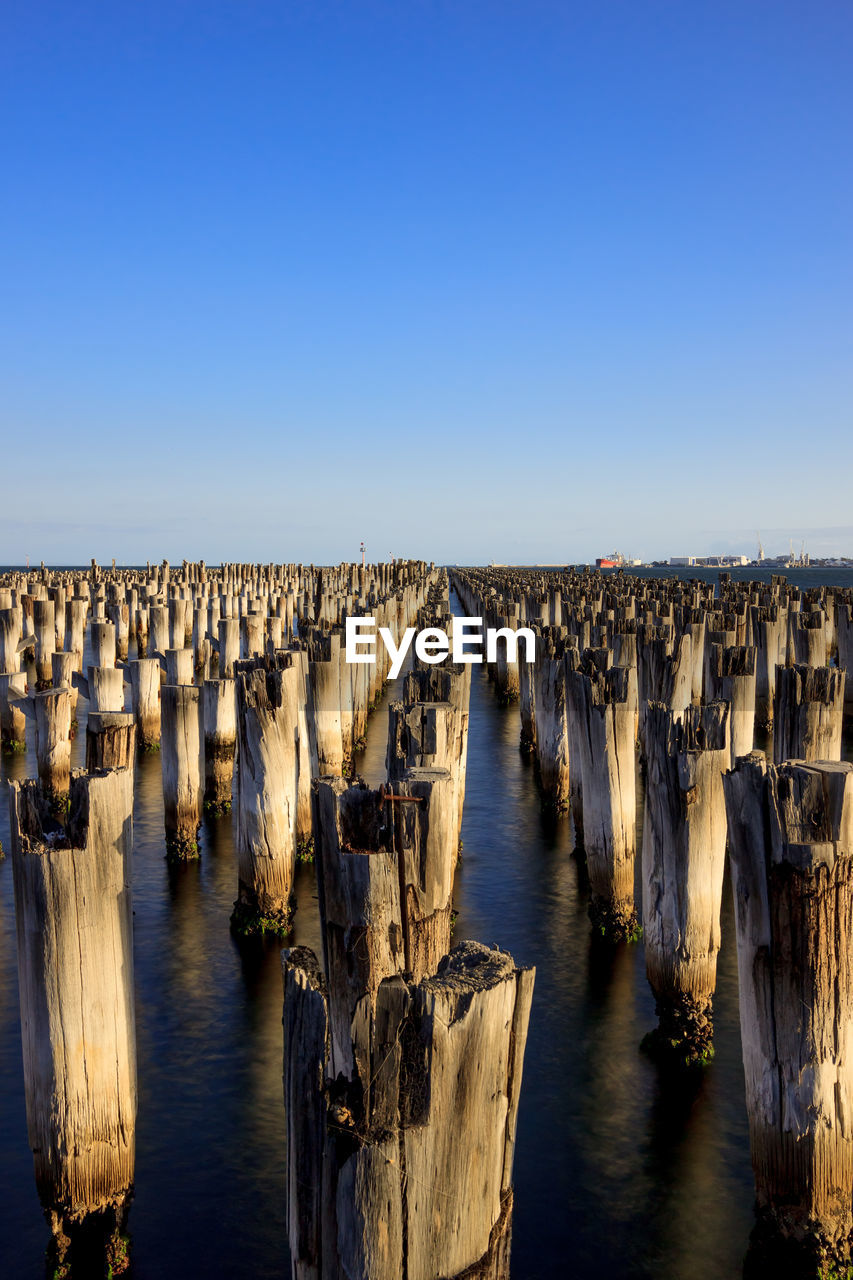 Wooden posts in front of sea