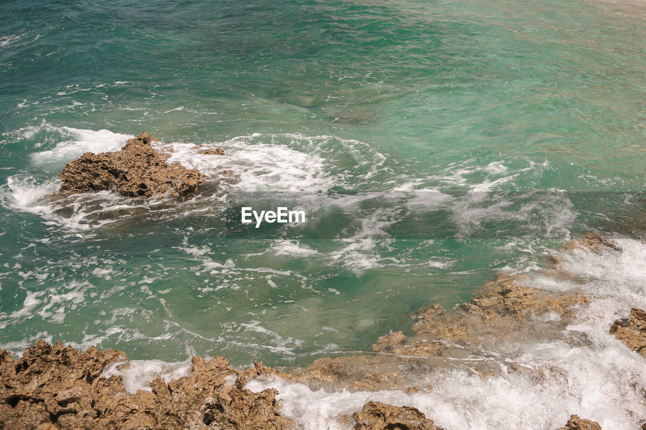 HIGH ANGLE VIEW OF ROCKS ON SHORE