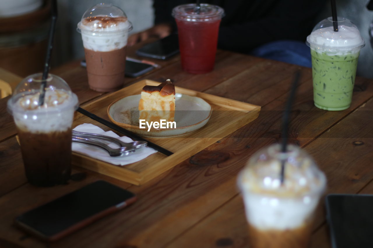 food and drink, drink, food, table, refreshment, glass, drinking glass, household equipment, soft drink, wood, indoors, meal, no people, freshness, restaurant, brunch, alcoholic beverage, dessert, dairy, plate, still life, coffee, selective focus, sweet food, healthy eating, candle