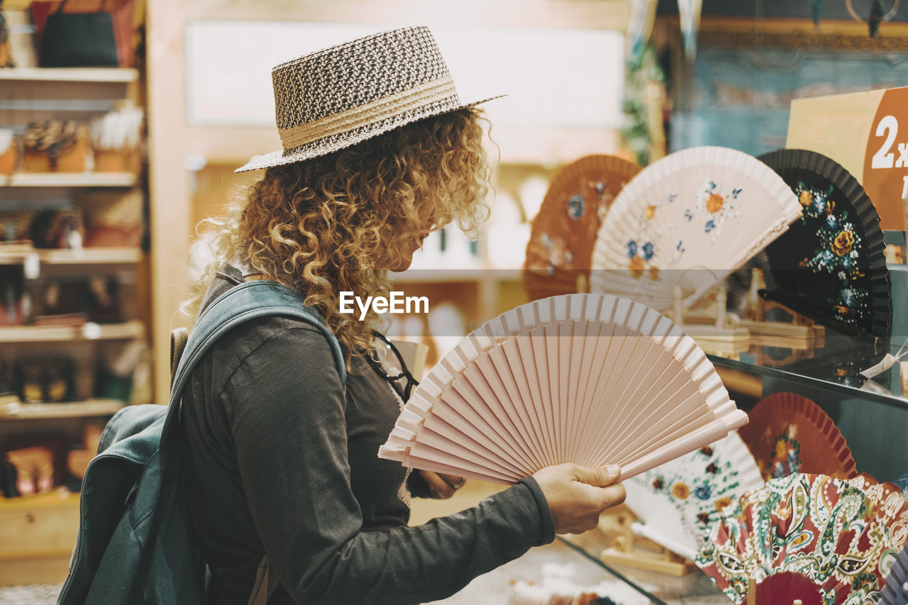 rear view of woman wearing hat standing in store