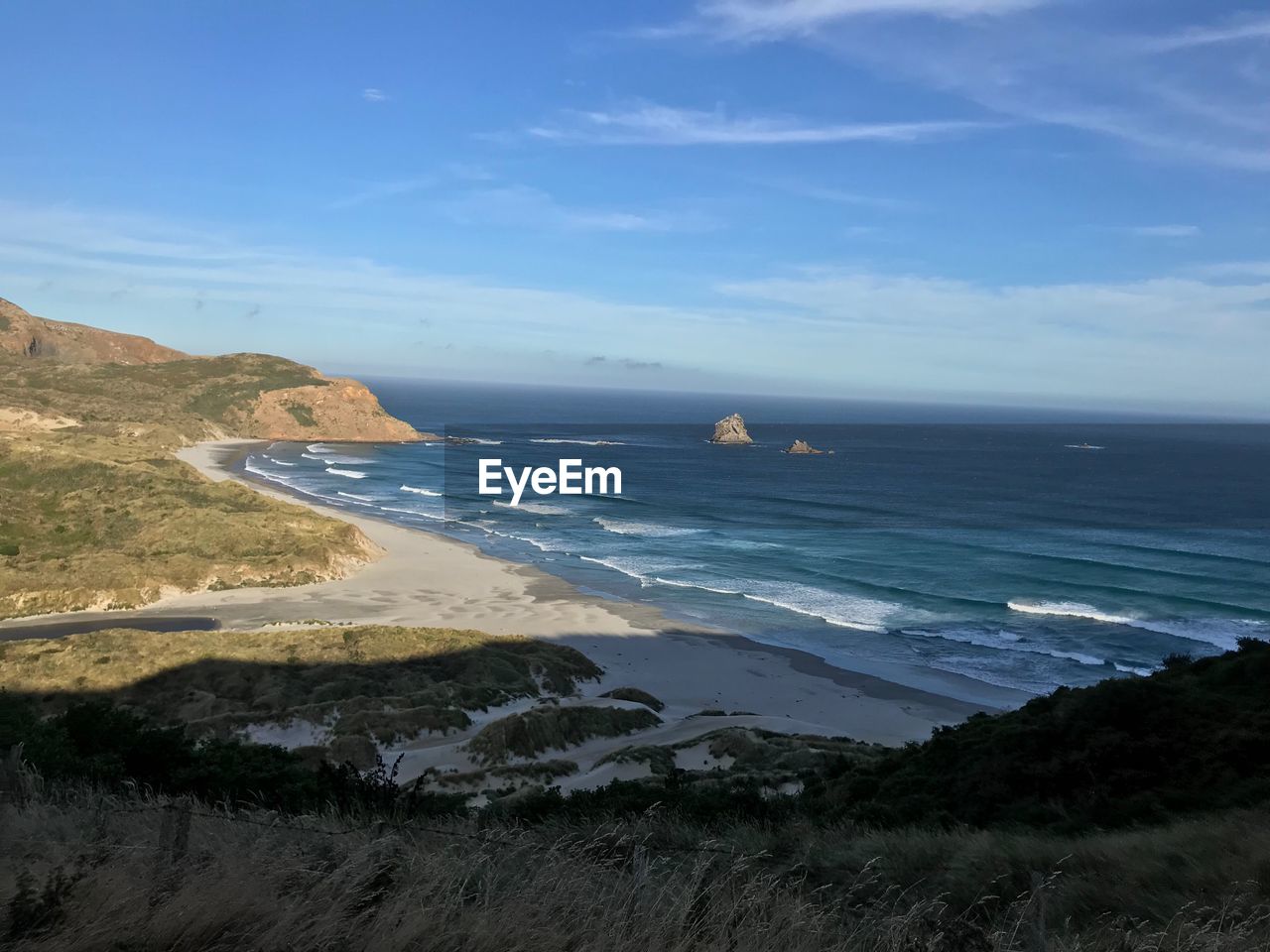 SCENIC VIEW OF BEACH AGAINST BLUE SKY