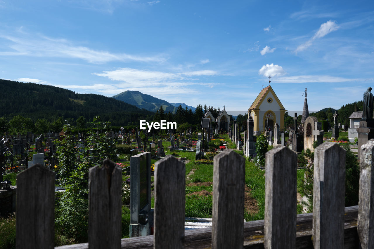 PANORAMIC VIEW OF CEMETERY AGAINST SKY AND MOUNTAIN
