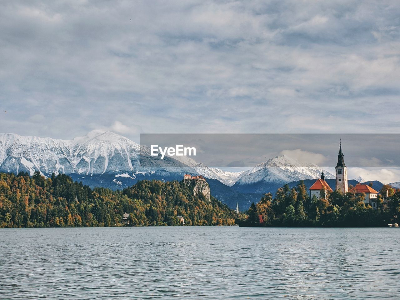 View of the snow-capped mountain peaks against the lake bled.