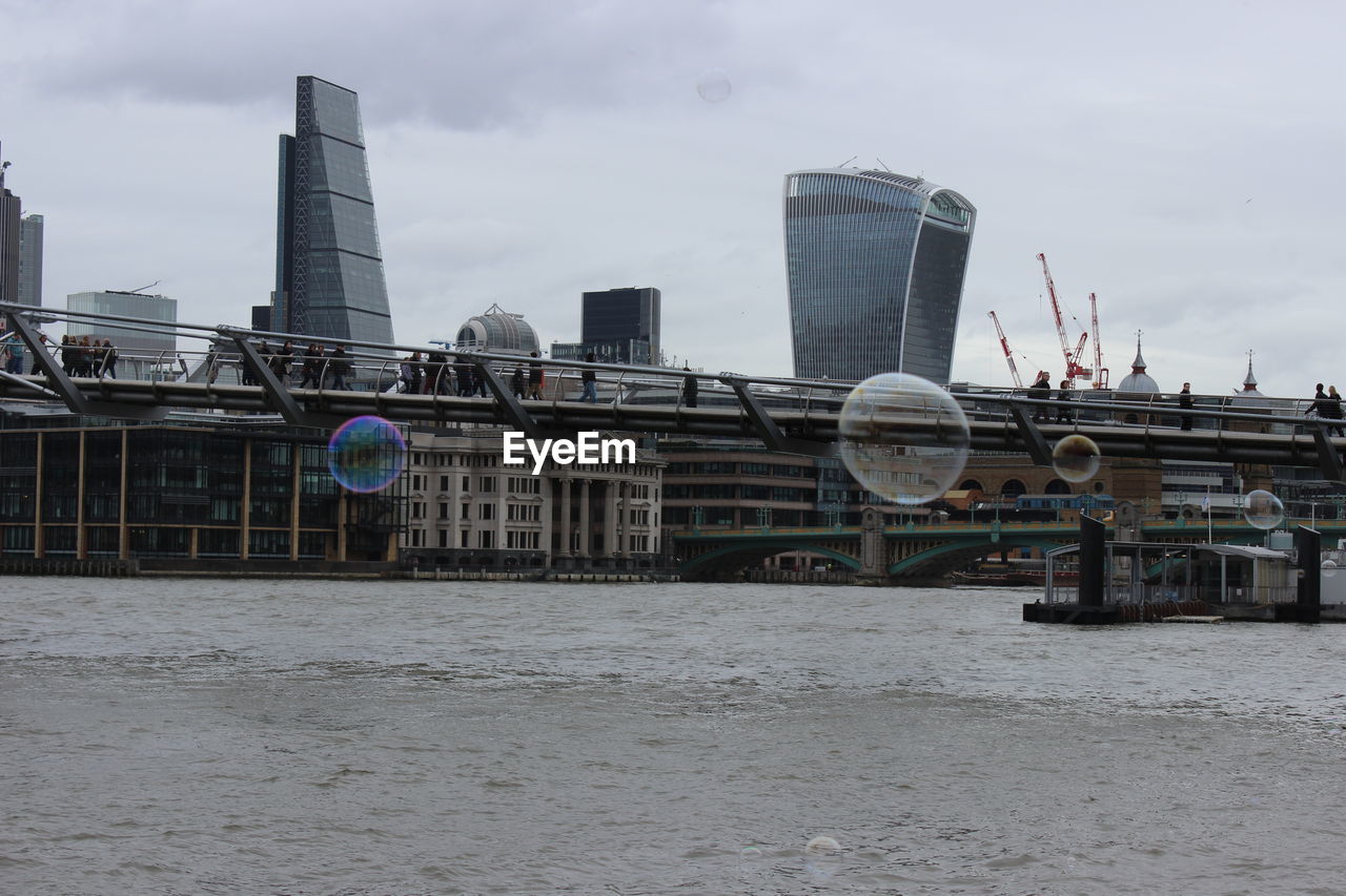 architecture, built structure, building exterior, city, sky, ferris wheel, day, skyscraper, bridge - man made structure, outdoors, no people, travel destinations, water, urban skyline, cityscape