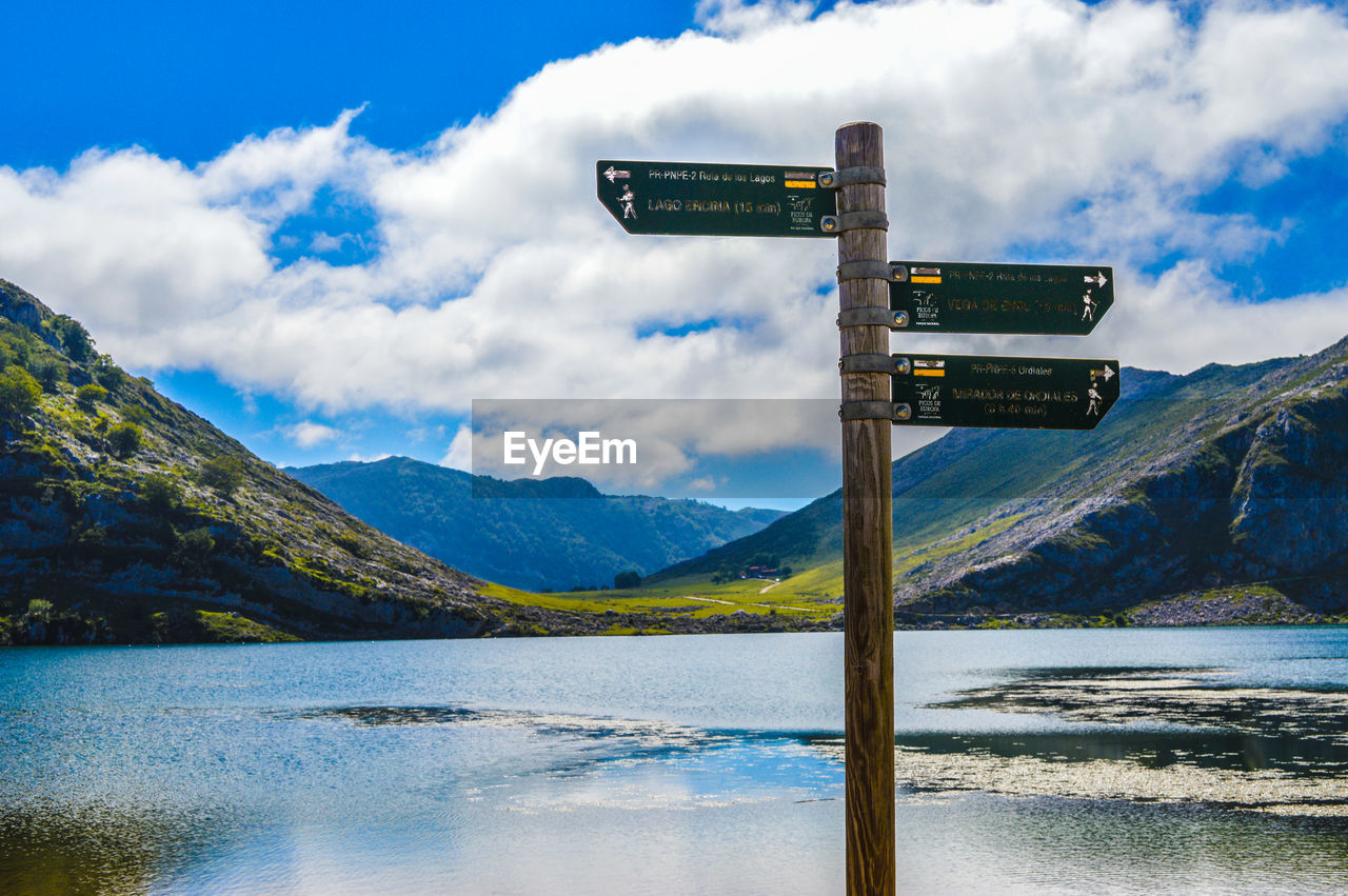 Scenic view of lake and mountains against cloudy sky