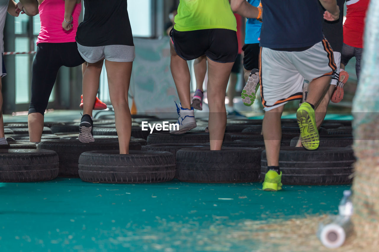 LOW SECTION OF PEOPLE WALKING ON SWIMMING POOL