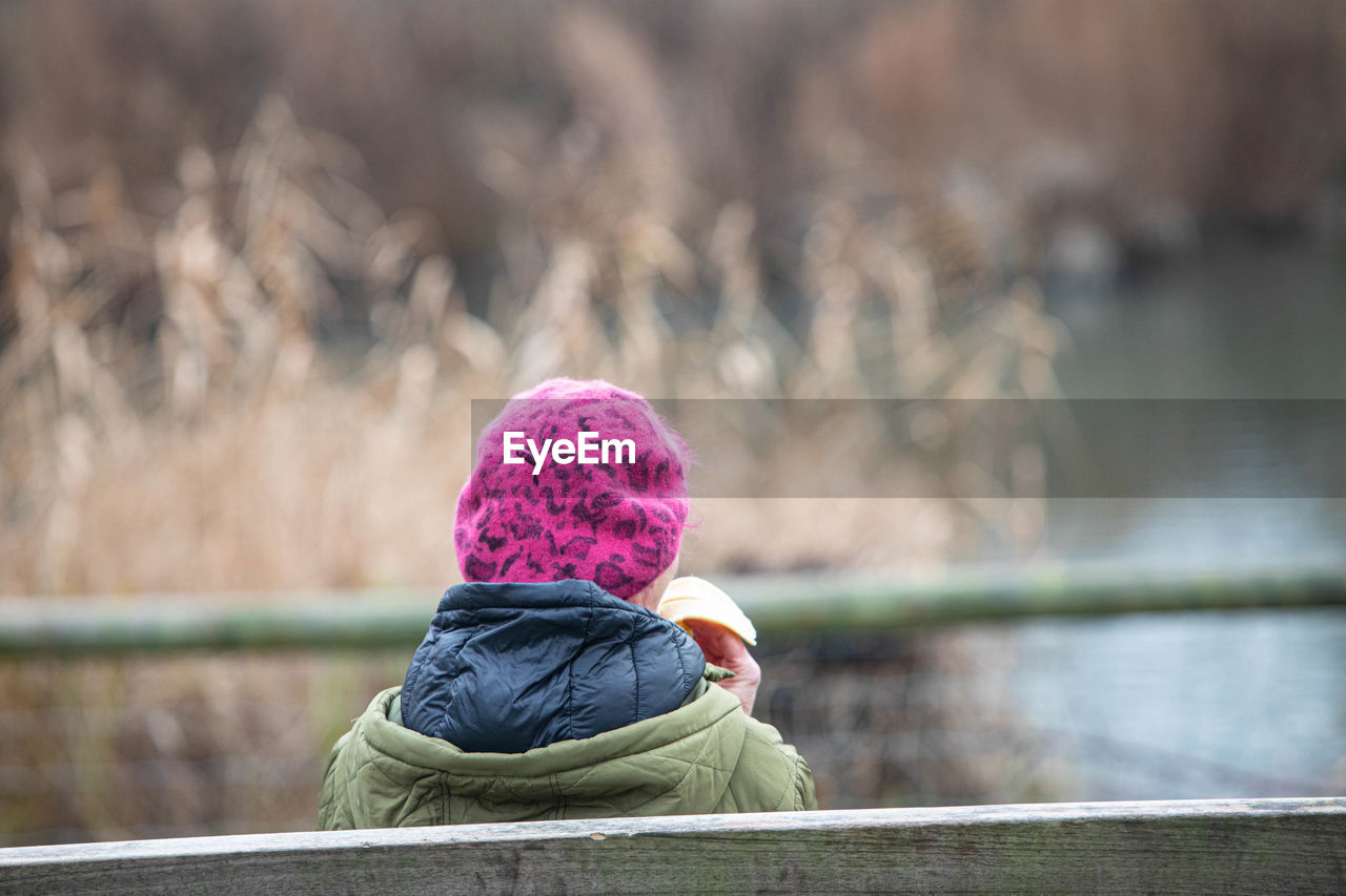 Rear view of woman in lake during winter