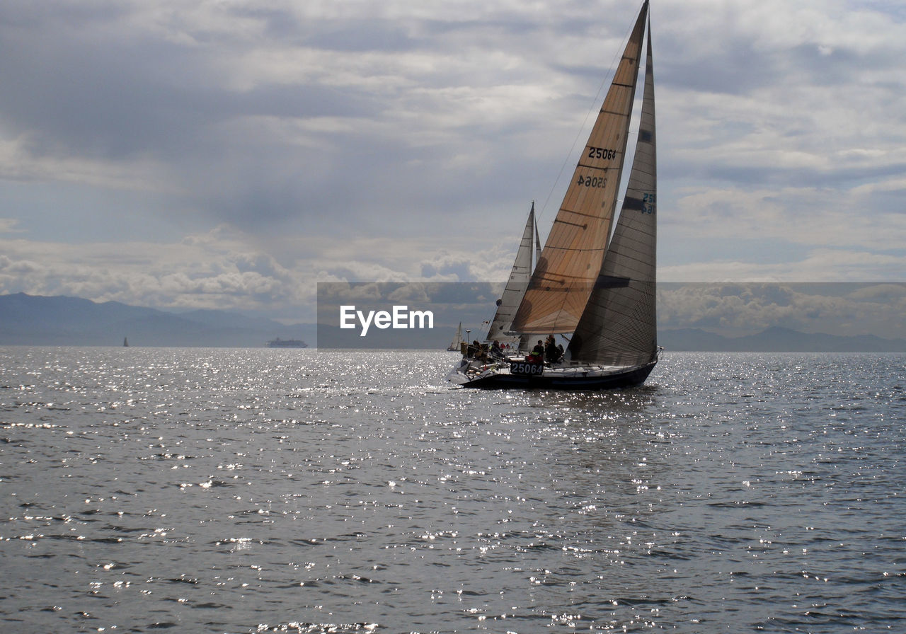 Sailboat sailing on sea against sky