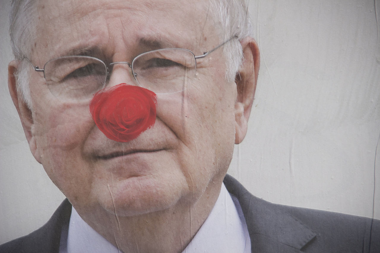 adult, one person, portrait, nose, headshot, human face, men, human head, person, senior adult, eyeglasses, glasses, emotion, close-up, indoors, front view, facial hair, gray hair, red, gray, facial expression, human mouth, seniors, mature adult, businessman, humor