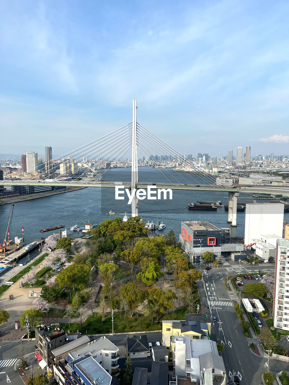architecture, built structure, city, transportation, building exterior, bridge, sky, cityscape, travel destinations, road, high angle view, nature, mode of transportation, motor vehicle, water, car, building, travel, street, suspension bridge, cloud, landmark, day, city life, office building exterior, no people, tourism, traffic, skyscraper, urban skyline, skyline, outdoors, land vehicle, aerial view, aerial photography, cable-stayed bridge, highway, city street, sea, metropolitan area, landscape, urban area, residential district, tower, nautical vessel, transport, overpass, plant, sunlight, downtown district, downtown, vehicle, tower block, bay, marina, tree