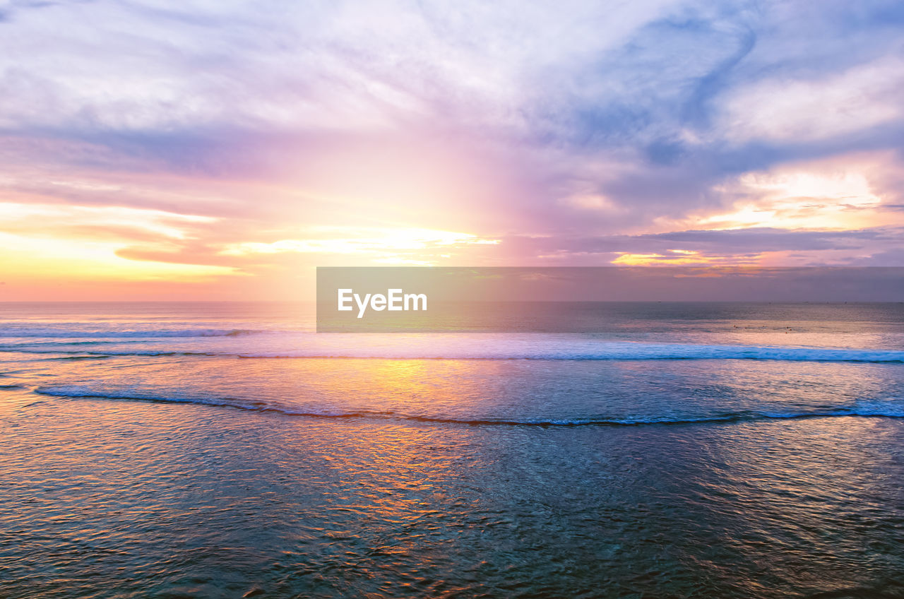 Sunset at the ocean with water ripple and small waves in the dark colors