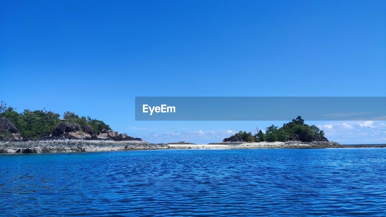 water, sea, sky, land, scenics - nature, blue, beauty in nature, nature, beach, tranquility, travel destinations, tranquil scene, island, body of water, islet, travel, shore, ocean, tree, no people, horizon, idyllic, clear sky, landscape, environment, archipelago, coastline, tourism, lagoon, vacation, coast, day, tropical climate, bay, plant, outdoors, trip, holiday, non-urban scene, cove, waterfront, architecture, sunny, summer, palm tree, mountain, rock, seascape, copy space, bay of water
