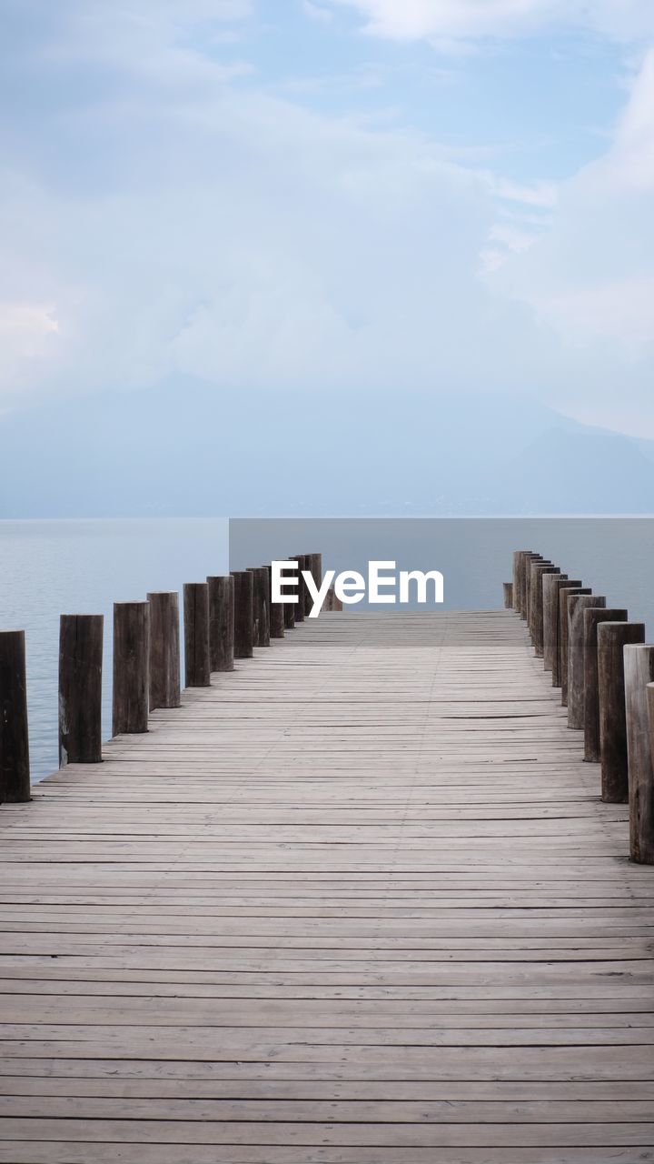 Wooden pier over sea against sky