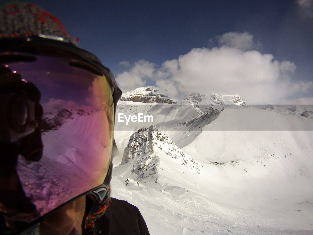 Person wearing helmet against snowcapped mountain