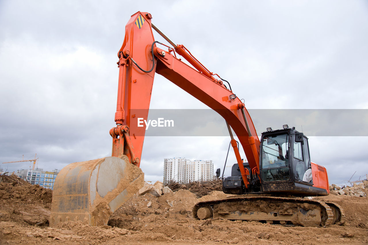 Red excavator during earthworks at construction site. backhoe digging the ground for the foundation
