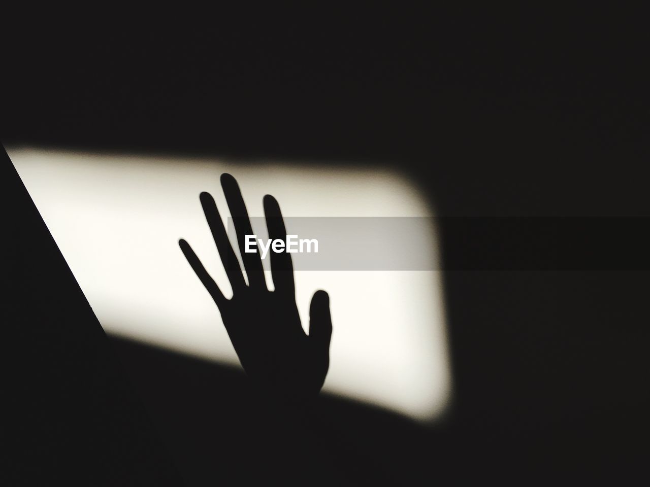 CLOSE-UP OF HAND TOUCHING SILHOUETTE OF PERSON