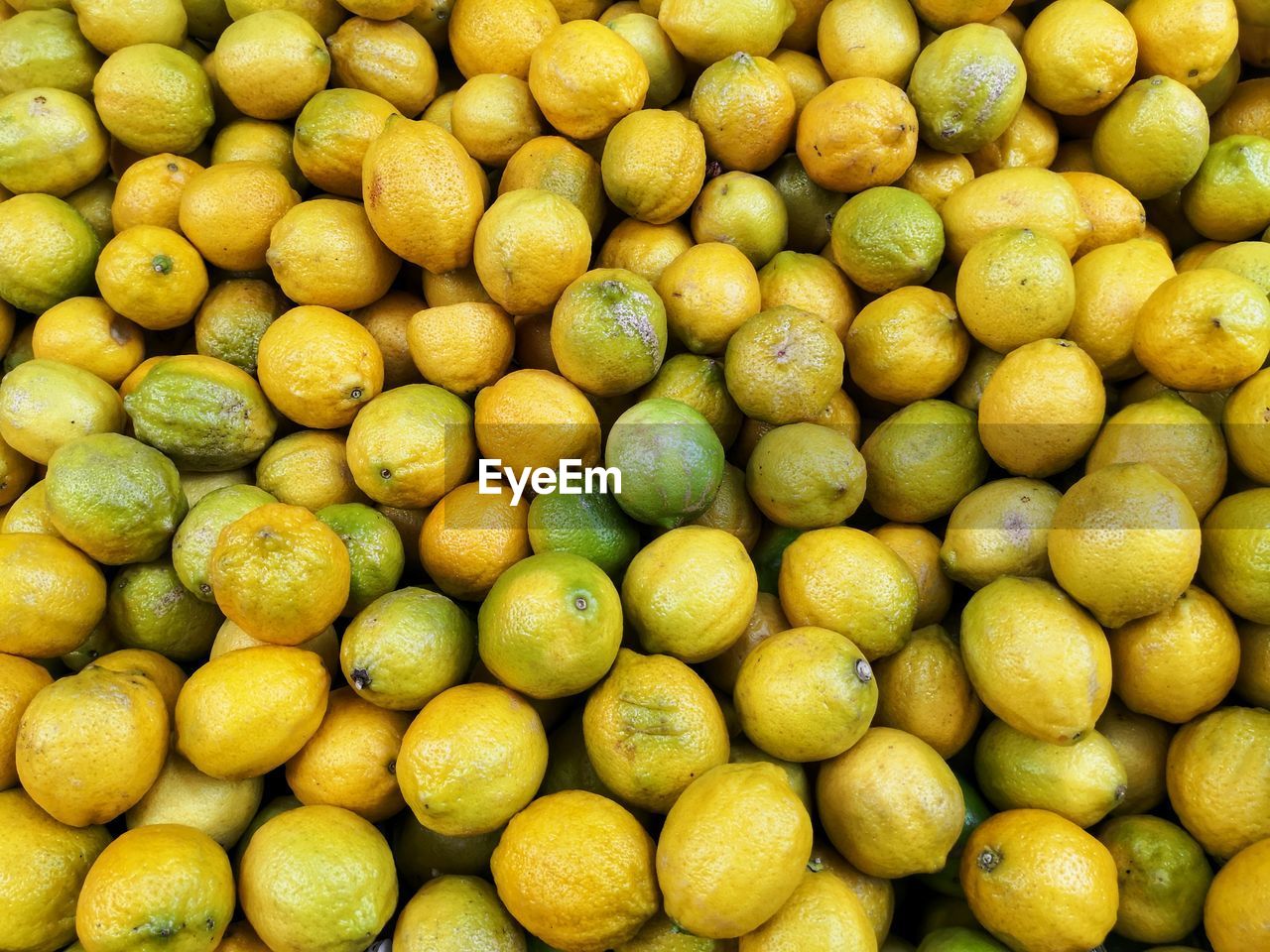 Green and yellow lemons at market