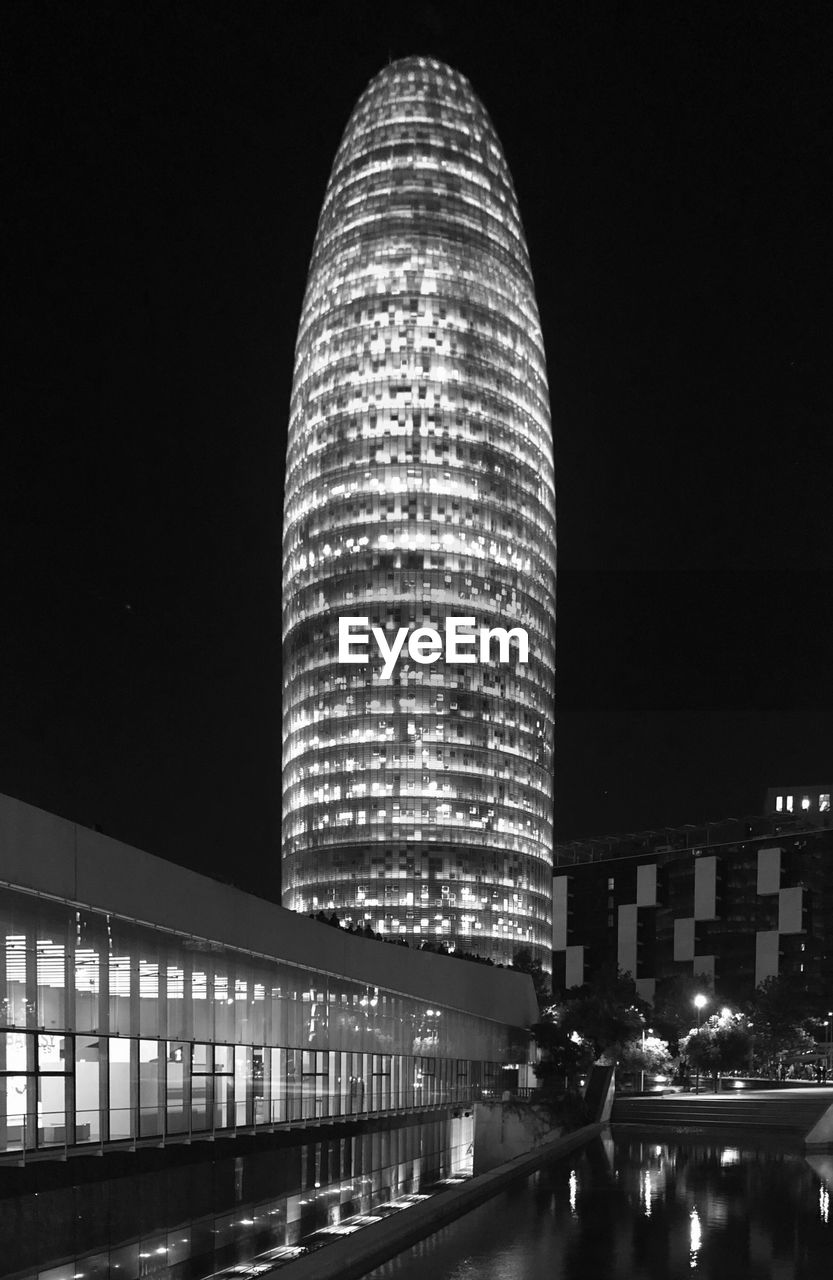 LOW ANGLE VIEW OF ILLUMINATED BUILDINGS AT NIGHT