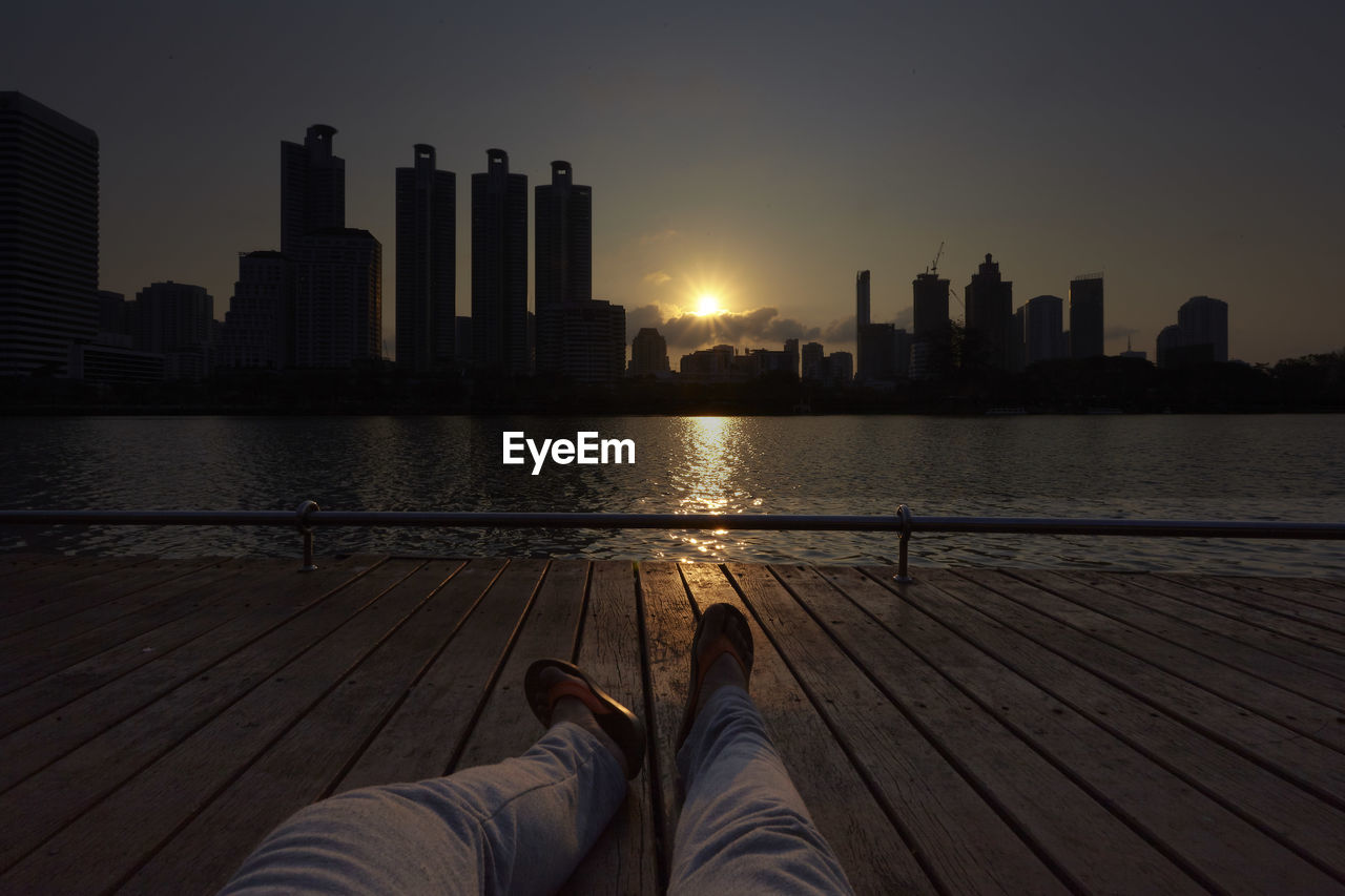 LOW SECTION OF MAN WITH SKYSCRAPERS IN BACKGROUND