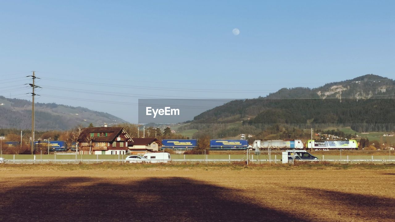 HOUSES ON FIELD AGAINST CLEAR SKY