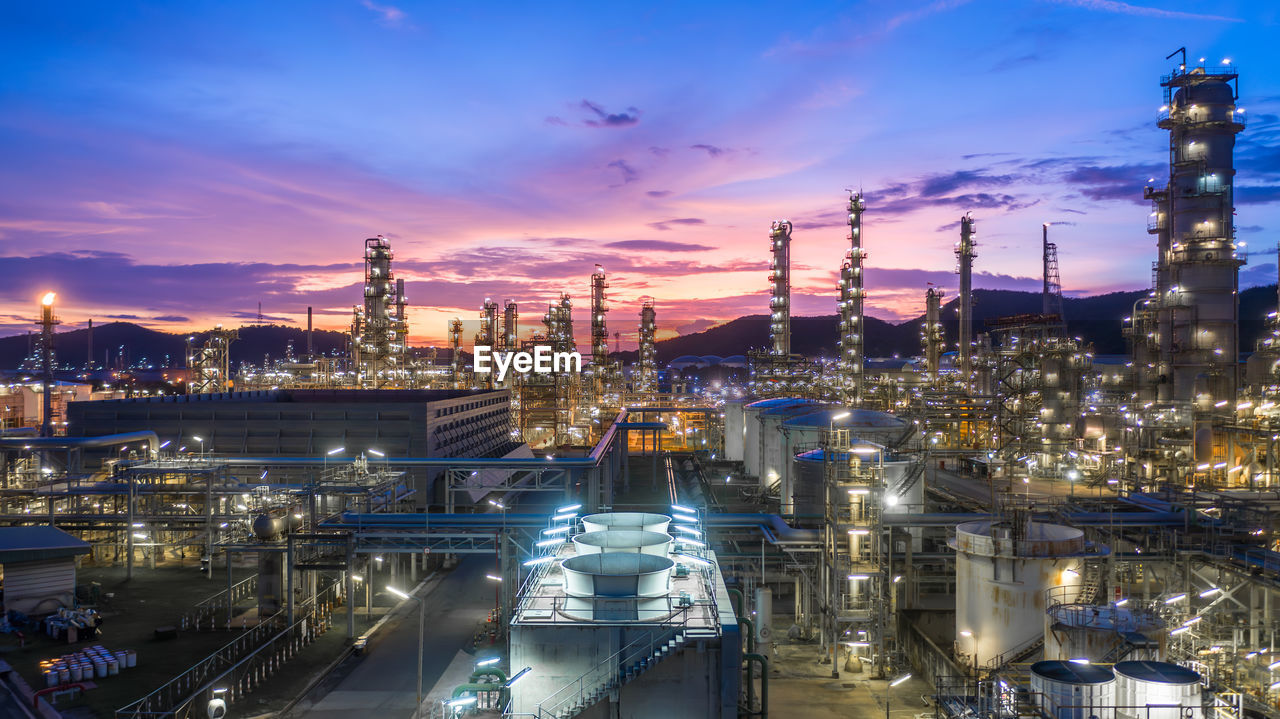 Aerial view oil and gas tank with oil refinery background at night, glitter lighting petrochemical.