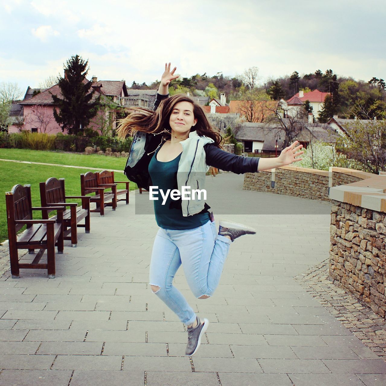 Portrait of happy woman dancing on footpath