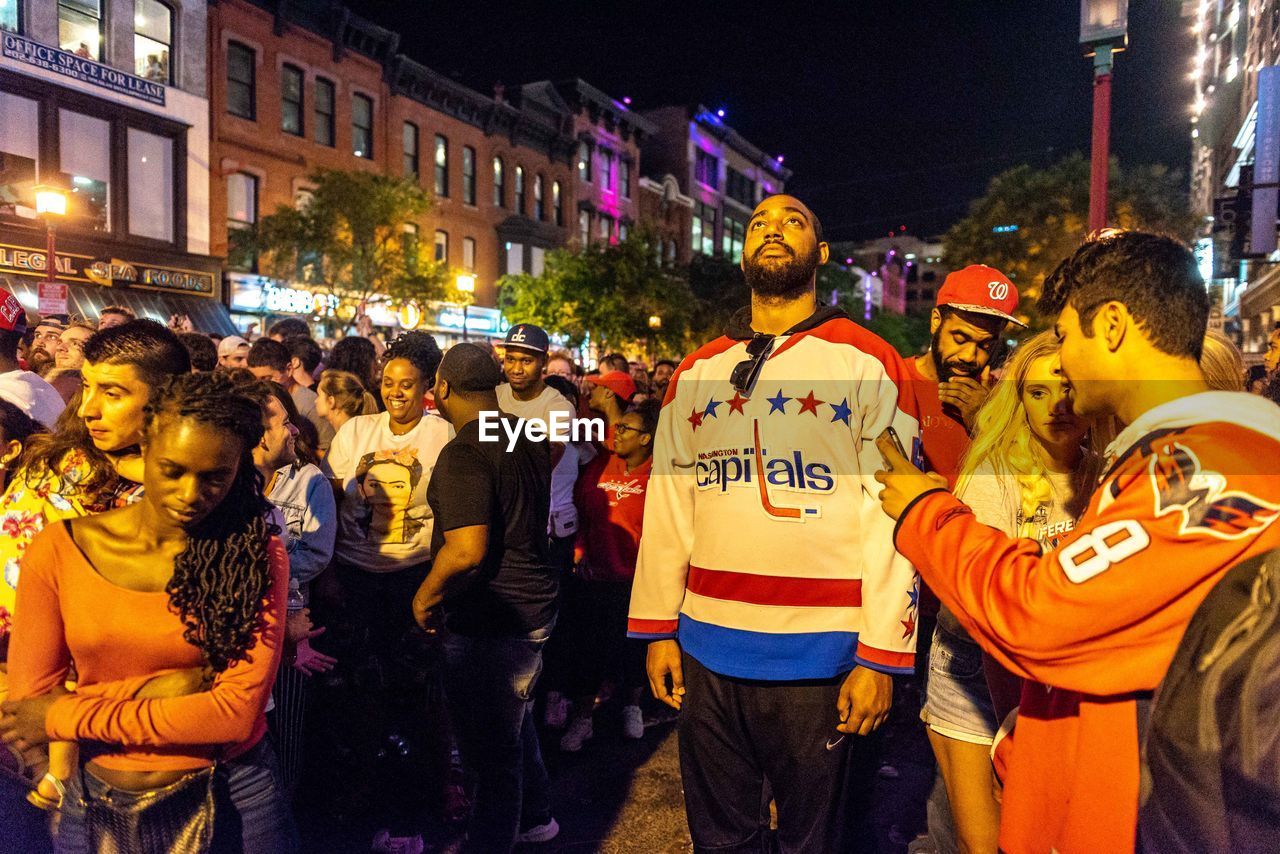 PEOPLE STANDING ON STREET IN CITY