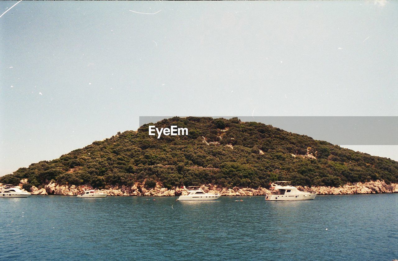 Scenic view of sea and mountains against clear sky