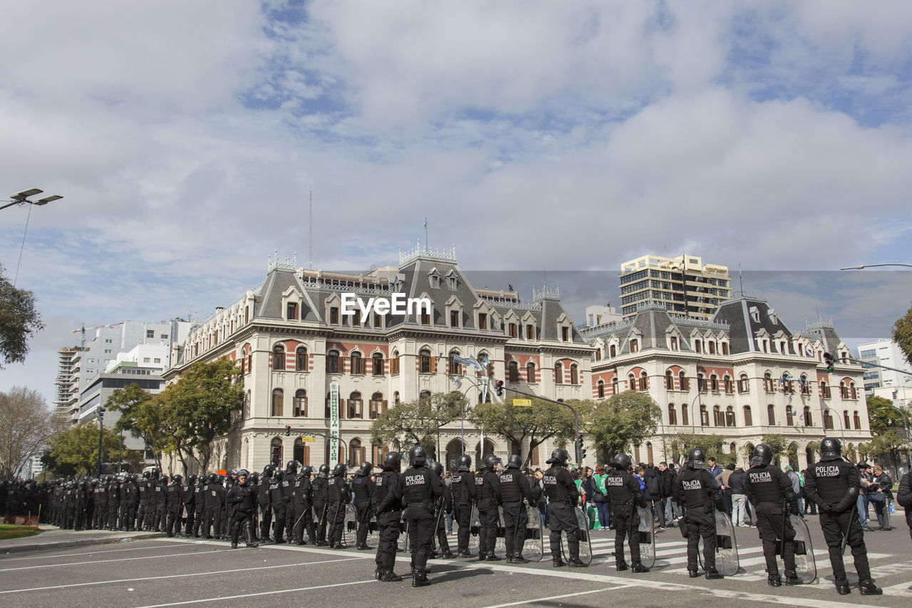 PEOPLE ON STREET AGAINST BUILDINGS IN CITY