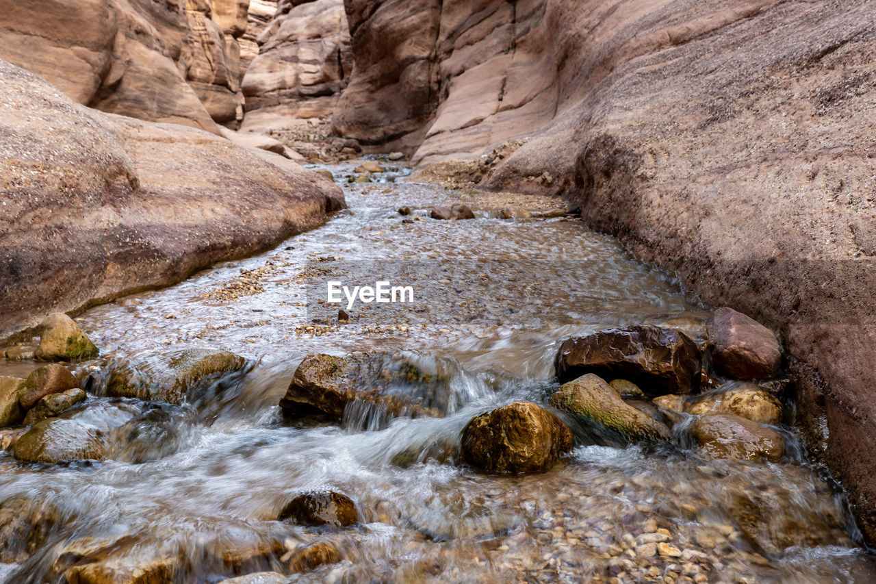 rock, nature, wadi, beauty in nature, water, scenics - nature, river, land, no people, wilderness, environment, geology, non-urban scene, rock formation, stream, valley, tranquility, day, landscape, outdoors, rapid, motion, flowing water, travel destinations, high angle view, travel