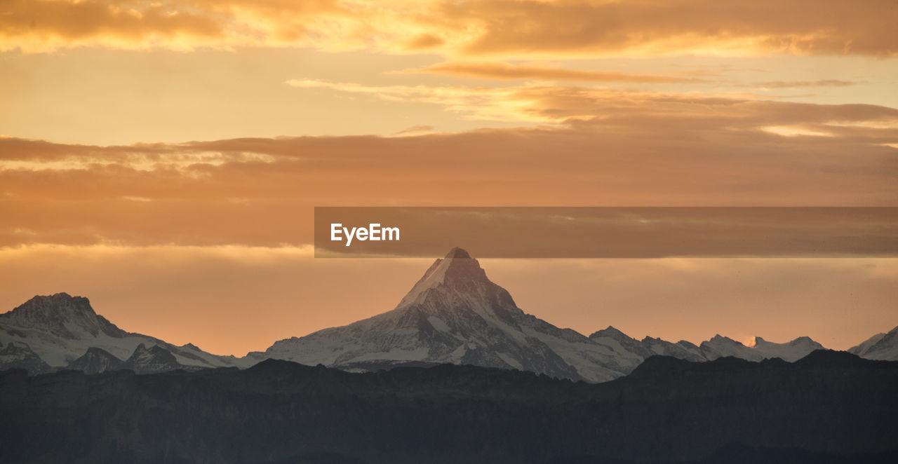 Scenic view of snowcapped mountains against sky during sunset